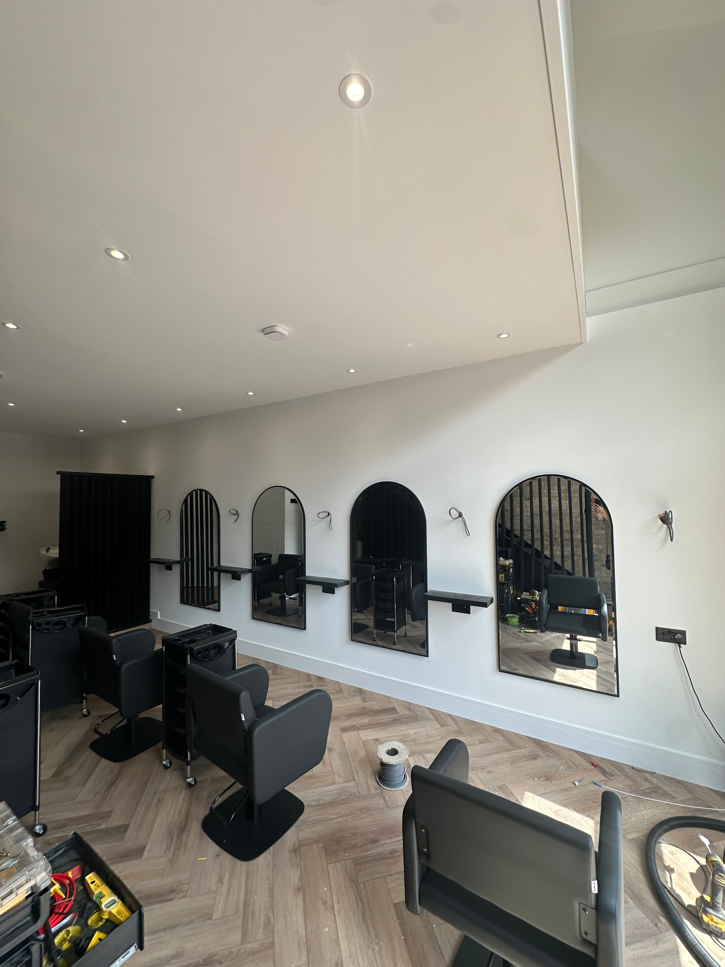 Salon fit-out with arched mirrors, shelving and herringbone flooring