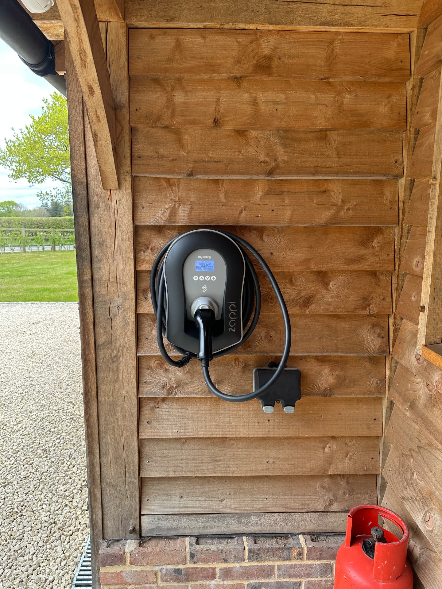 Zappi EV charger neatly mounted on a timber-clad wall