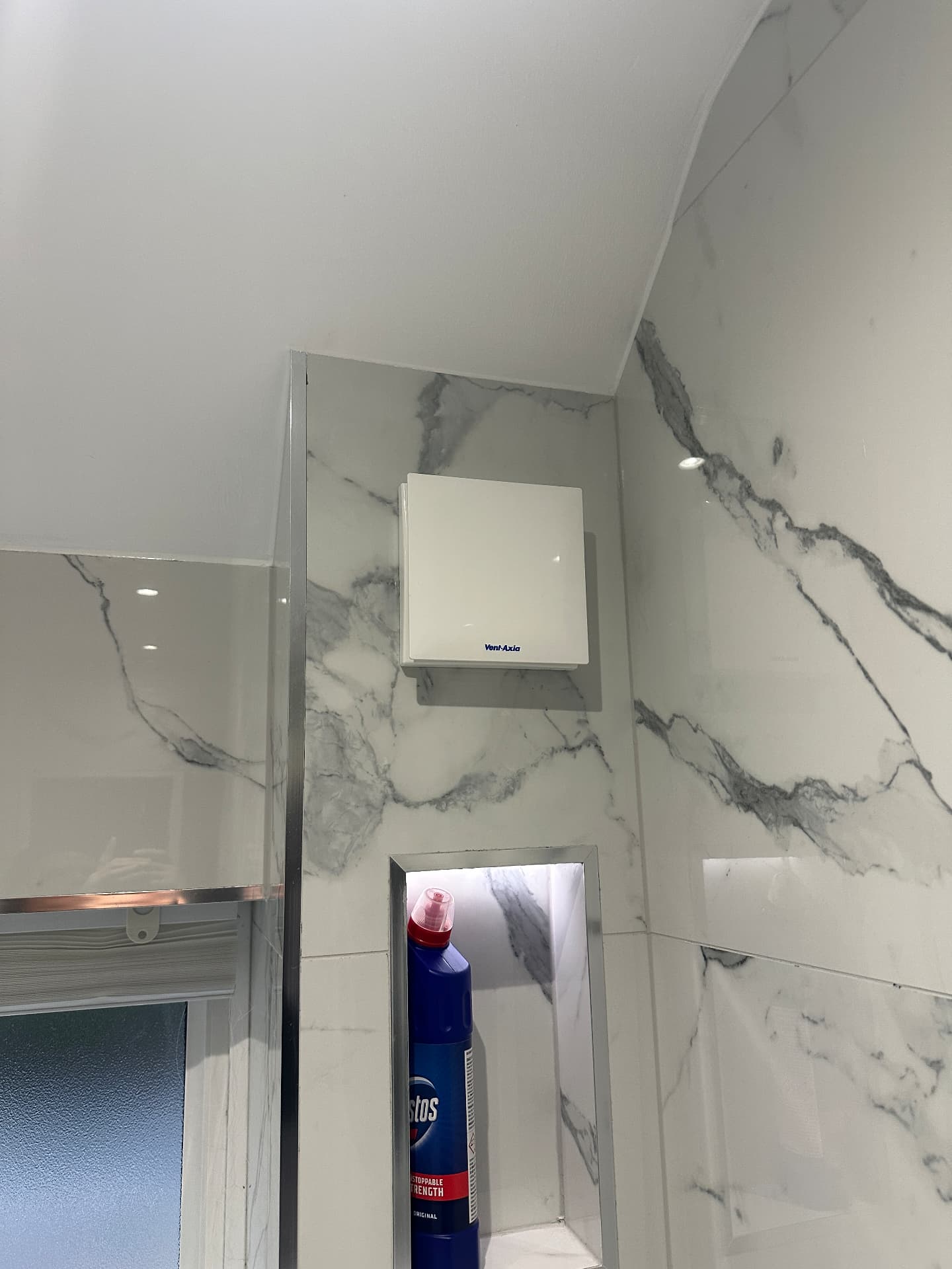 Bathroom extractor fan fitted neatly into marble-effect tiling