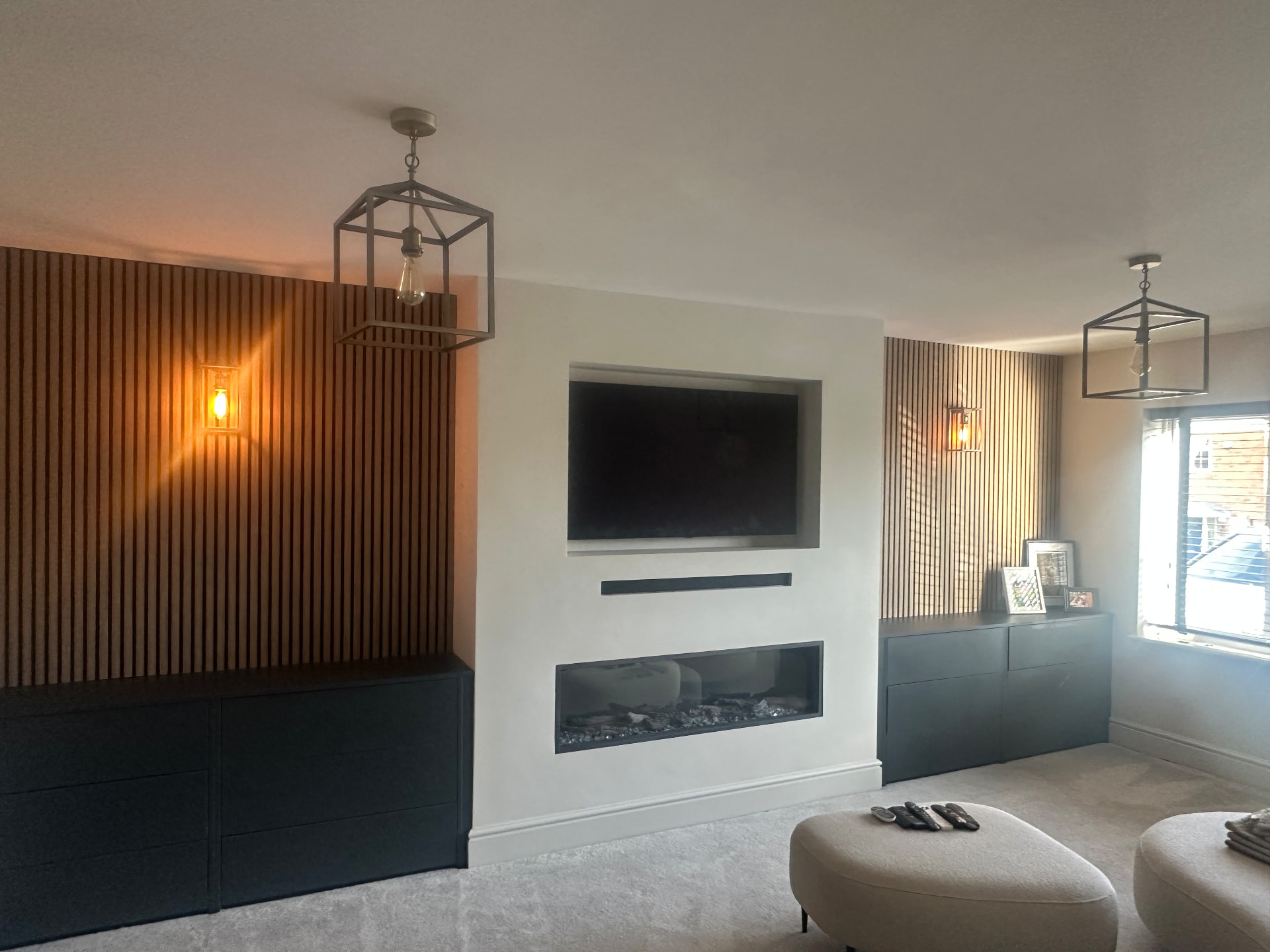 Lounge media wall with inset TV, electric fire and oak slat panelling