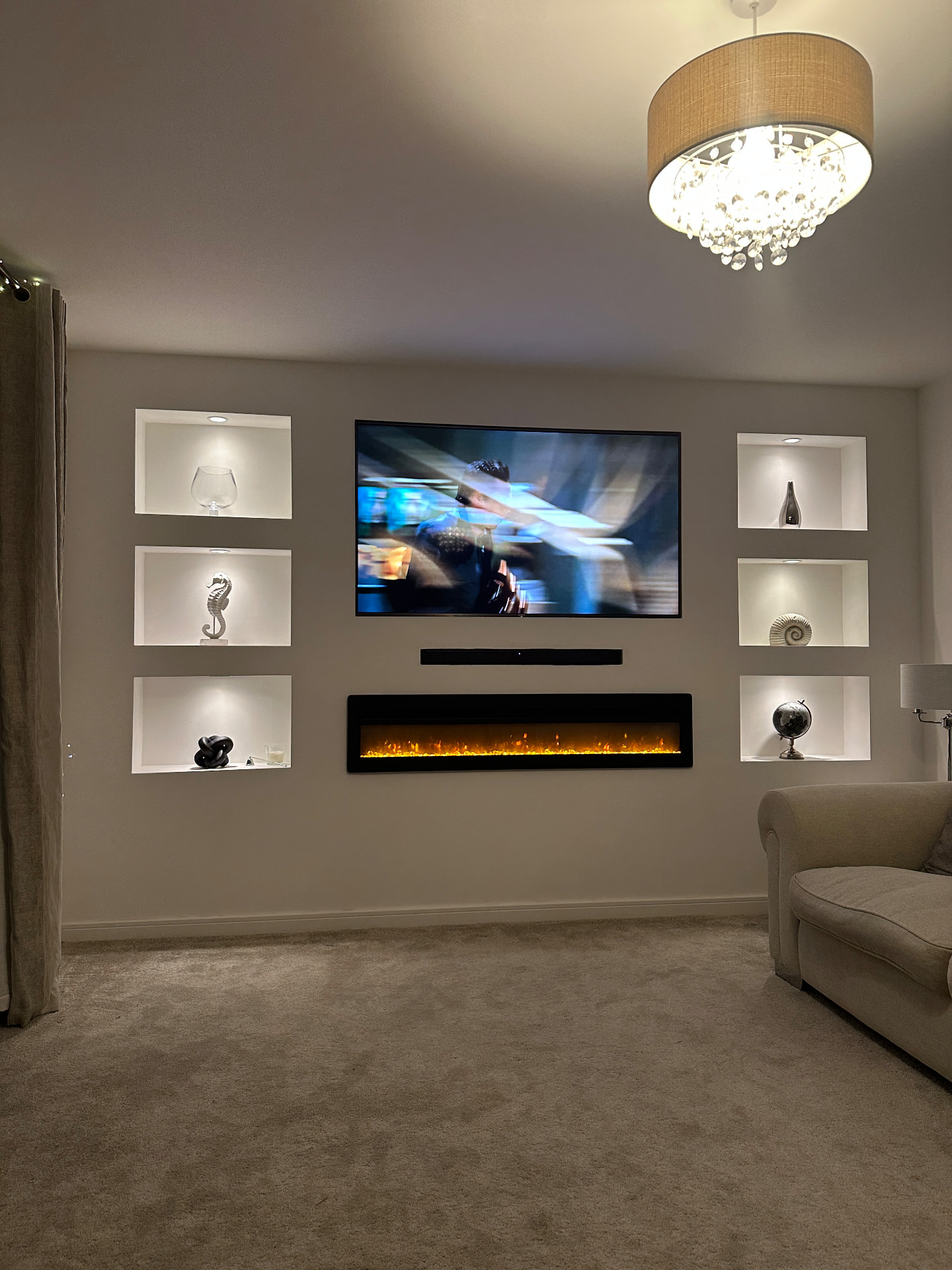Premium media wall installation with electric fireplace and downlight alcoves