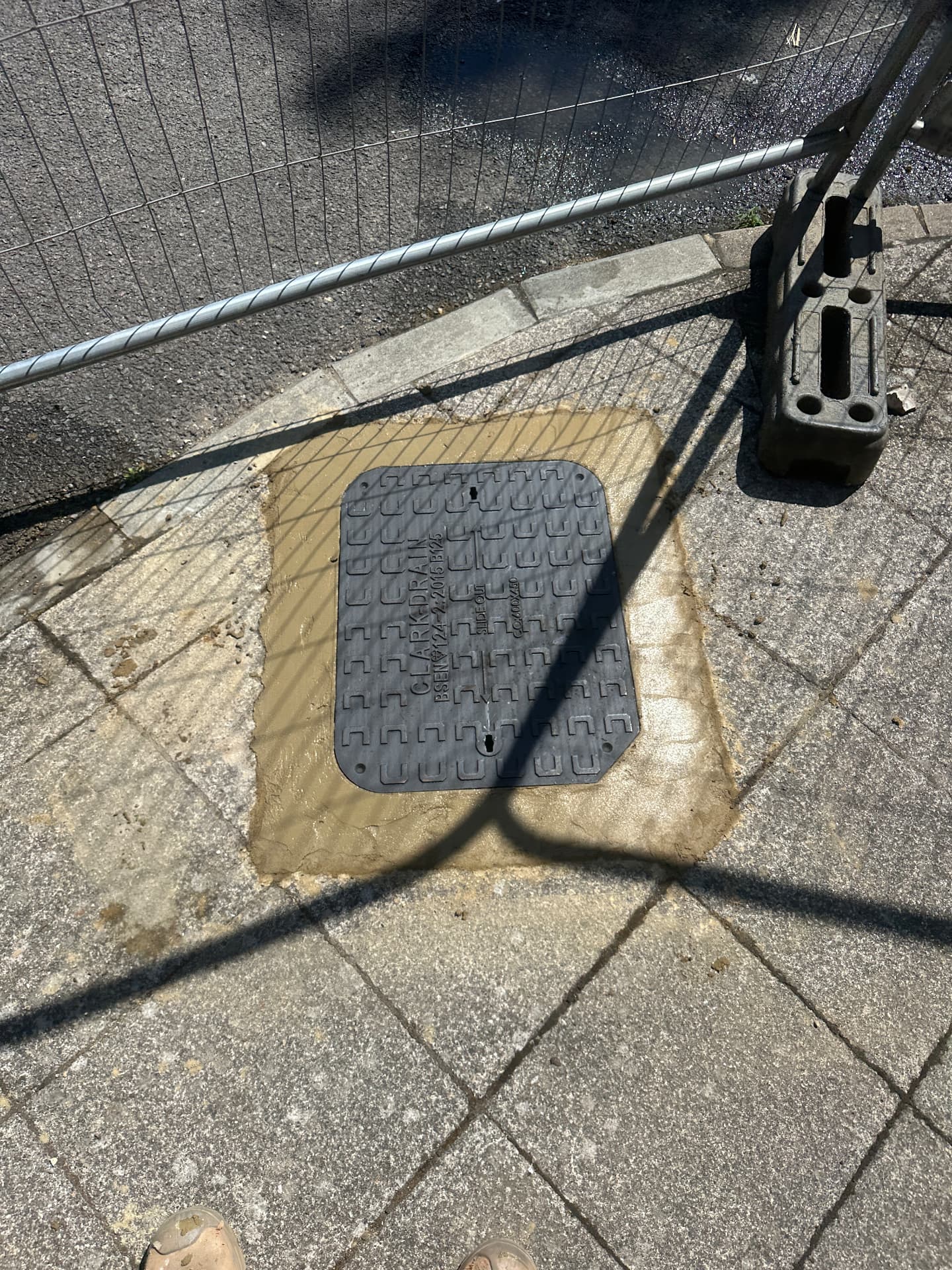 New drain cover set into paving with a clean mortar finish